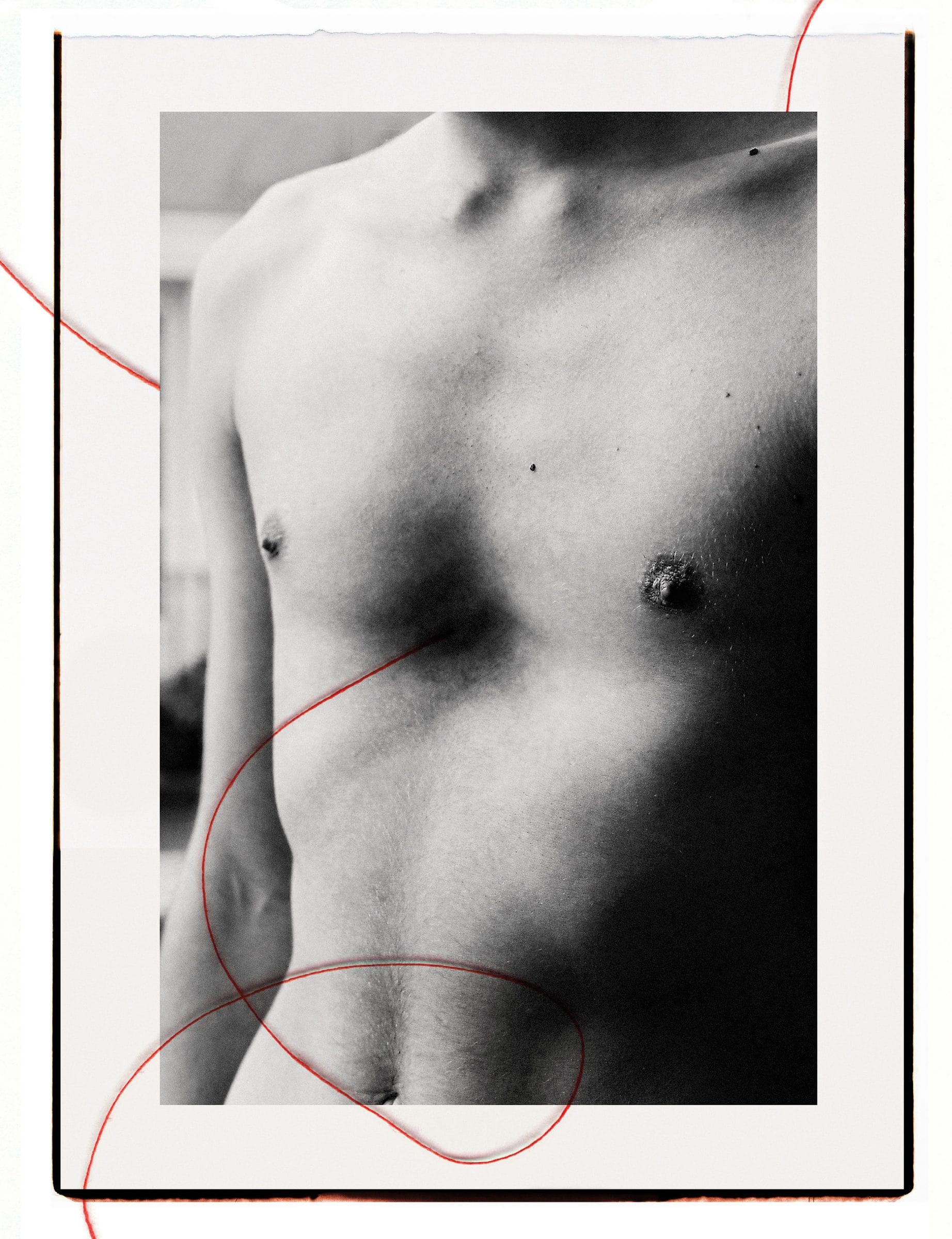 Fotografía en blanco y negro del torso desnudo de una persona, rodeada por un hilo rojo.