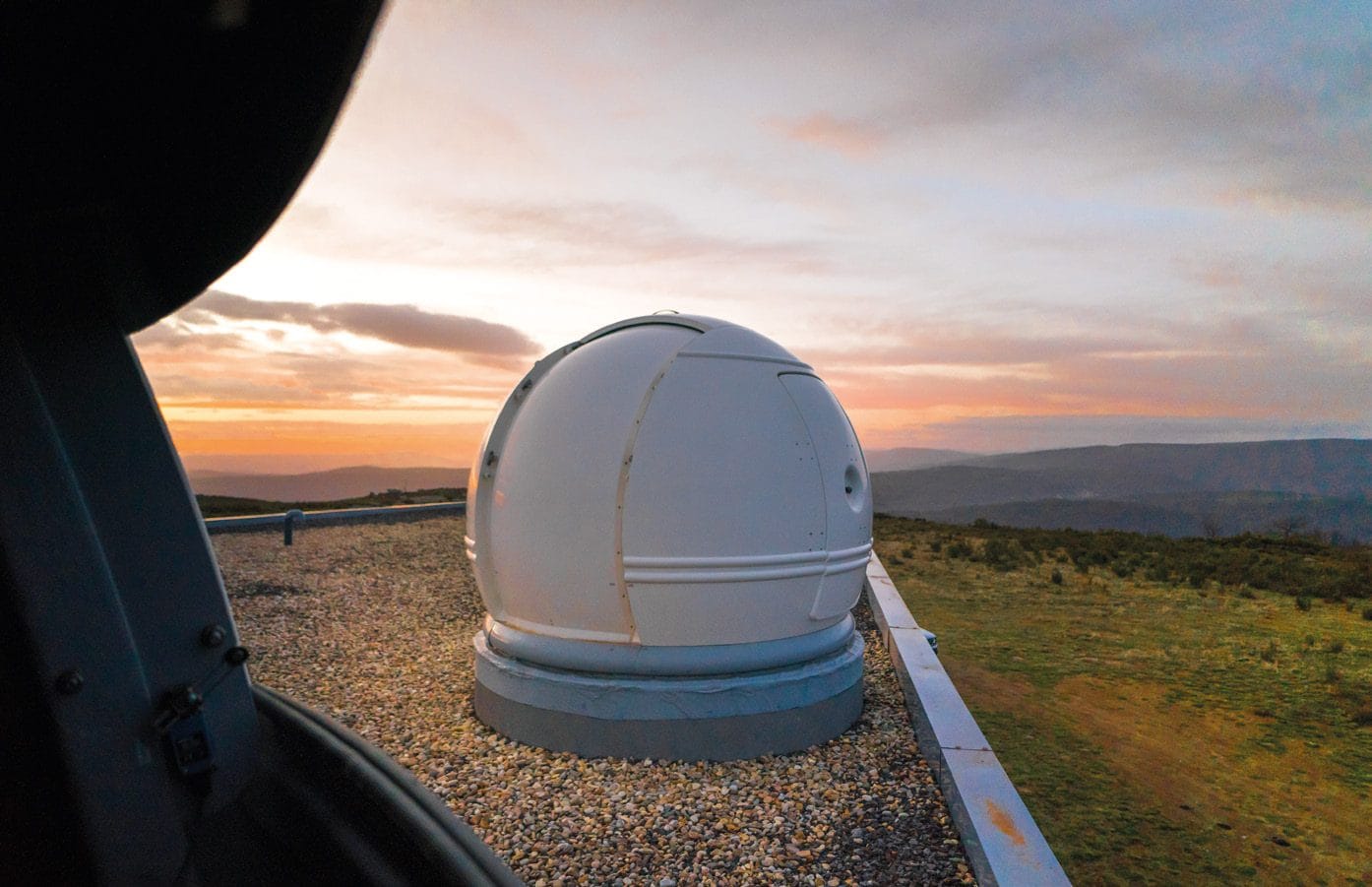 Una de las cúpulas del observatorio de Trevinca al atardecer, vista desde el interior de otra cúpula abierta.