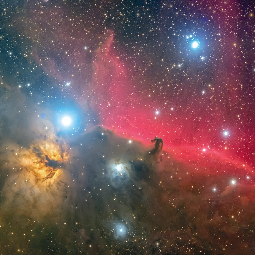 La nebulosa Cabeza de Caballo B33, recortada en oscuro sobre una nube de gas roja, junto a la nebulosa de la Llama.